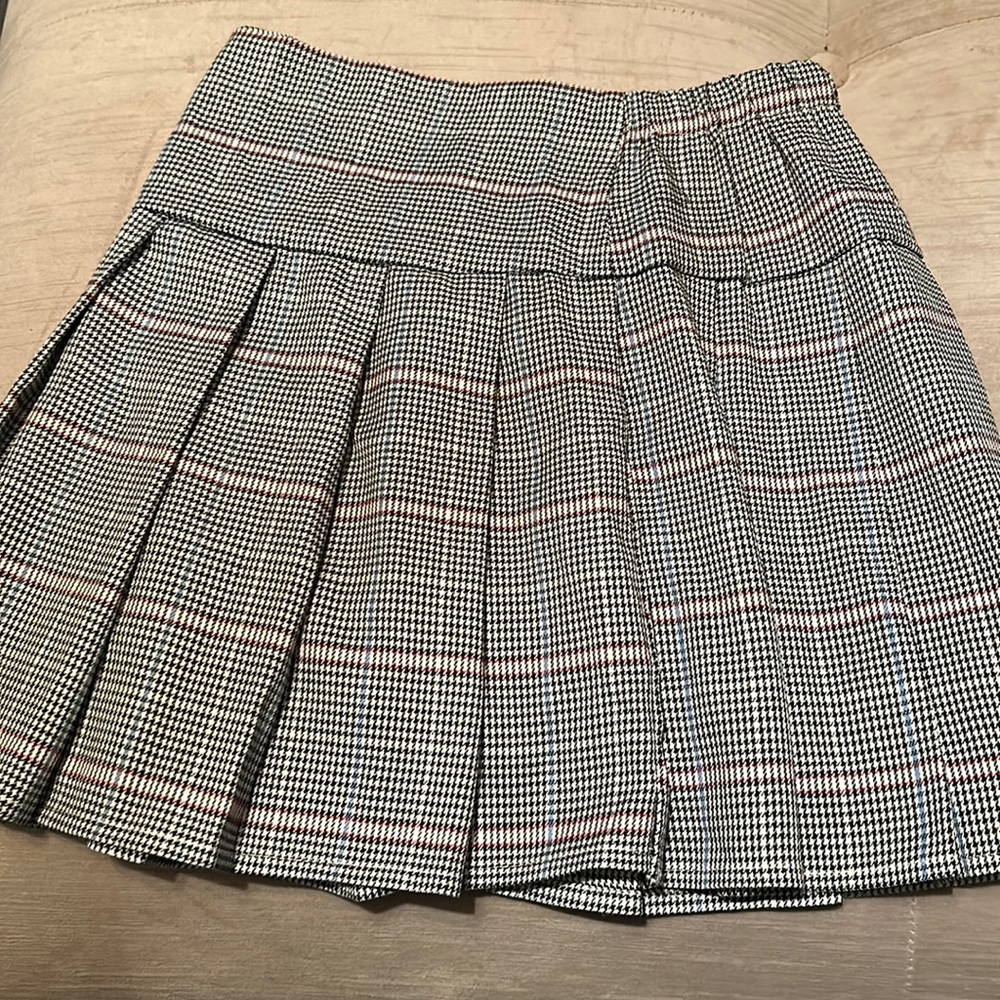 Nice Top and bottom! Pleated black, blue, white skirt. White long sleeve.